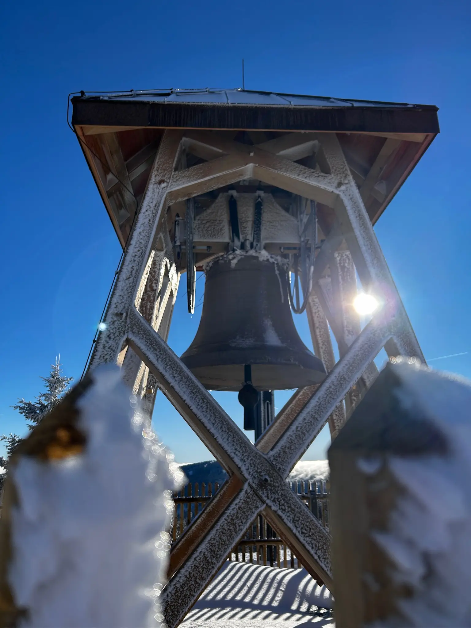The iced Peace Bell Agnes seen from below through the fence